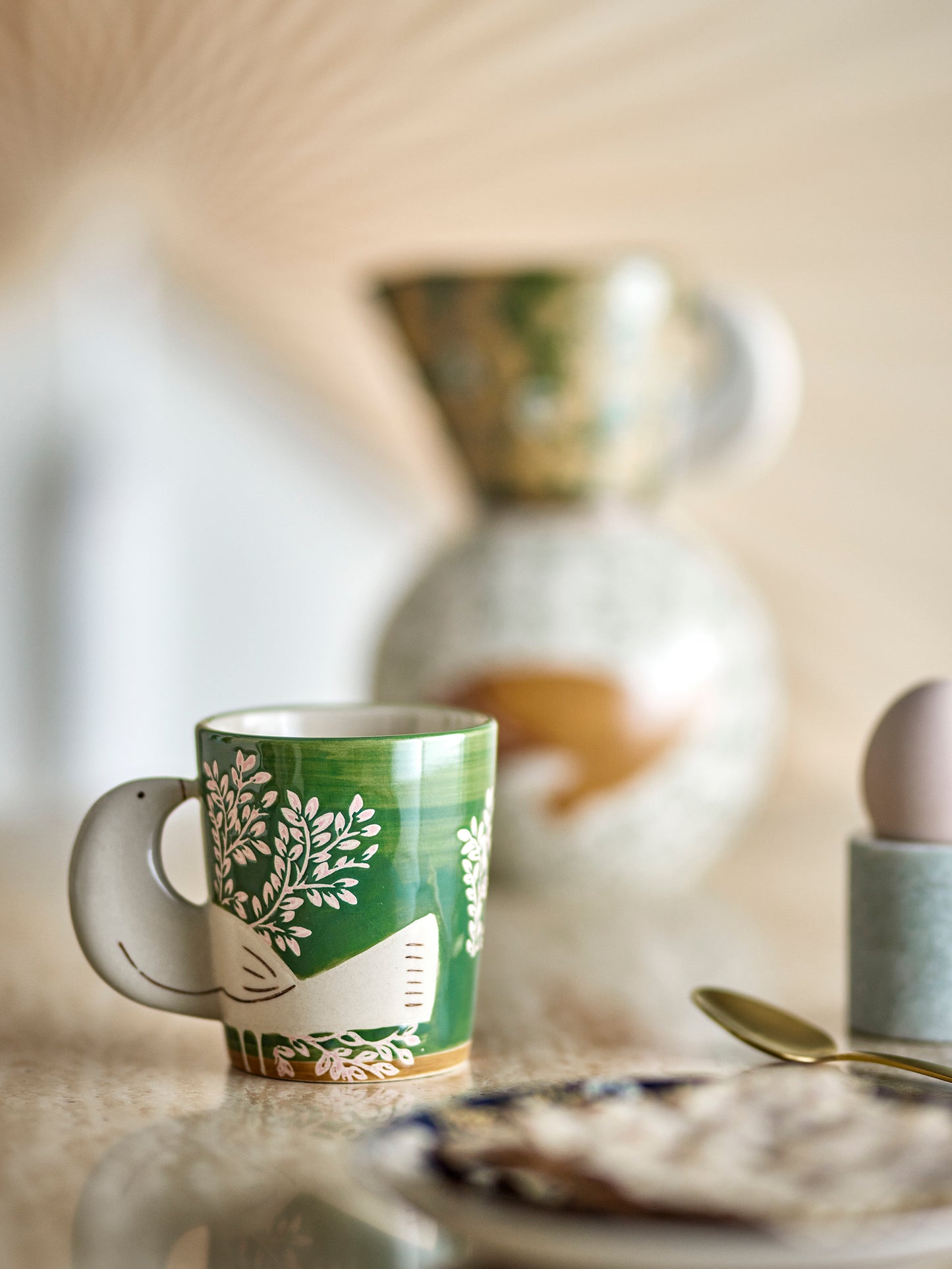 Die Tasse Hezha als dekorative Tasse auf einem gedeckten Esstisch.