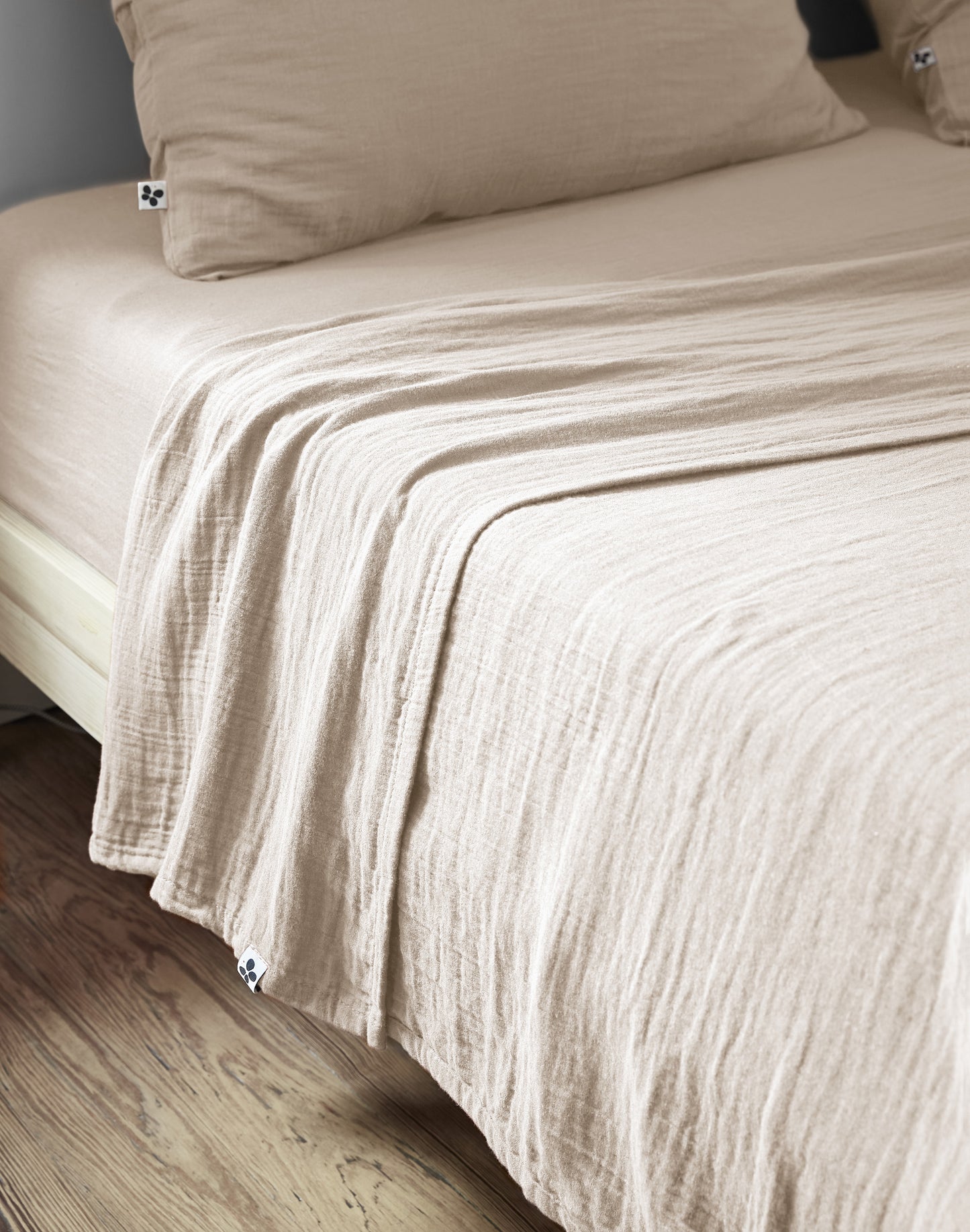 Riesige XXL-Musselin-Überwurfdecke Pampa aus Baumwollgaze in Beige-Creme auf einem Doppelbett.