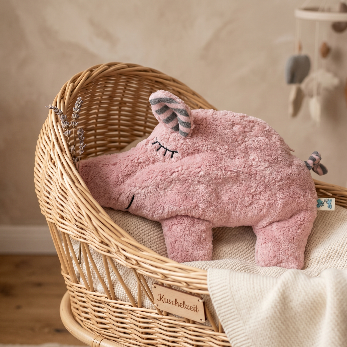 Das minimalistische Schweinchen-Wärmekissen gemütlich angerichtet in einer Baby-Wiege im natürlichen Licht.