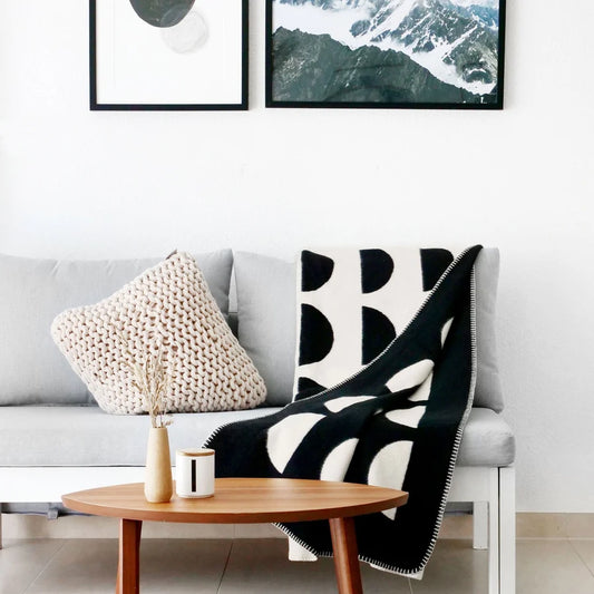 Kuscheldecke Joris im modernen Scandi-Wendedesign locker über ein graues Sofa drapiert für gemütliche Wohnzimmer-Deko.