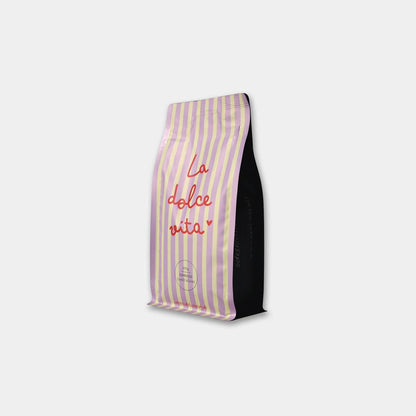 Liebevoll gestaltete Kaffeetüte mit lila gelben Streifen und Aufschrift La dolce Vita.