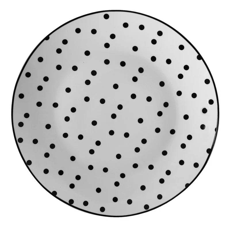 Kleiner weißer Porzellanteller mit feinen schwarzen Punkten (Ø 20 cm) in der Gesamtansicht vor hellem Hintergrund.