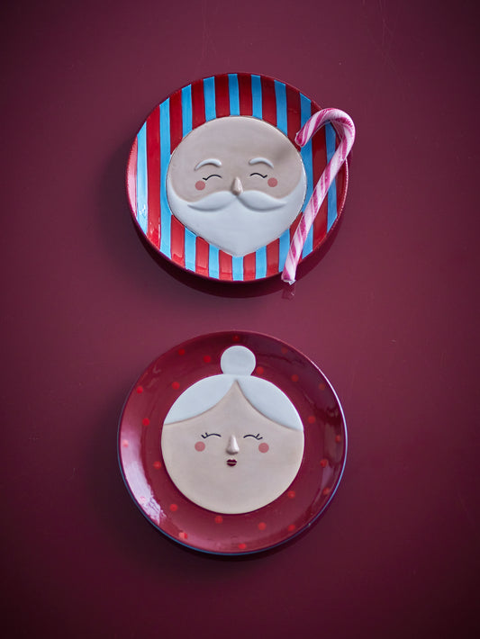 Teller-Set Granny Weihnachten mit Oma- und Opa-Gesicht im 2er-Set in der Gesamtansicht vor rotem, weihnachtlichen Hintergrund