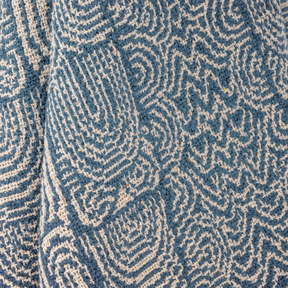 Nahaufnahme der gewebten Textur und des blau-weißen Musters der Decke Bresso.