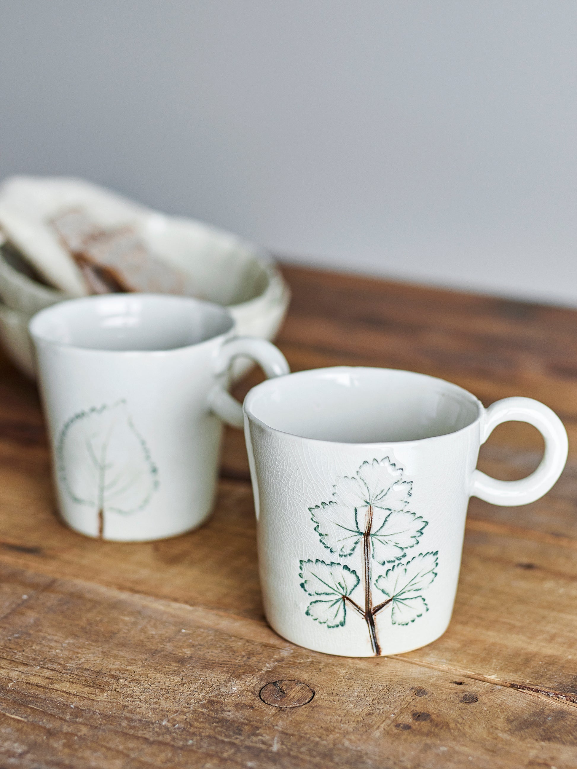 Das Tassen-Set Aubrin gemütlich arrangiert bei einer Kaffeepause auf einem Holztisch.