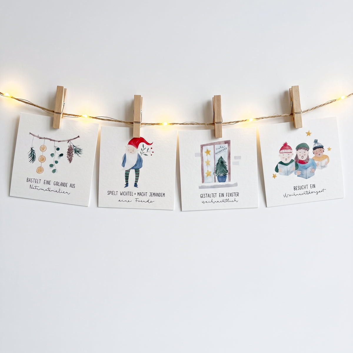 Adventskalender mit verschiedenen Aufgaben für die ganze Familie, hängt an einer beleuchteten Lichterkette und wurde mit hölzernen Wäscheklammern daran befestigt.