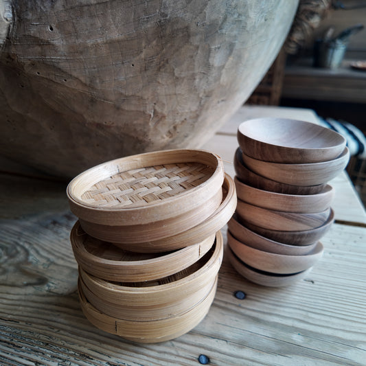 Mehrere Bambusschalen übereinander gestapelt auf einem Holztisch.