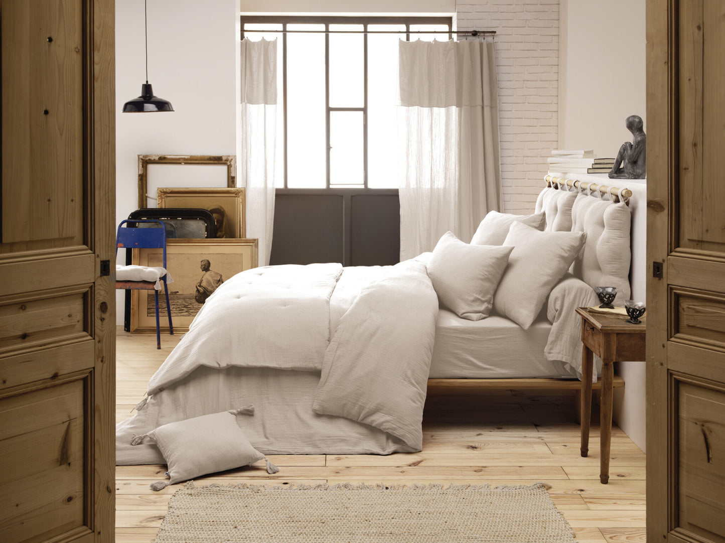 Die beige Kuscheldecke als dekorativer Überwurf auf einem hölzernen Tagesbett.