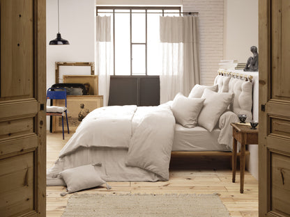 Die beige Kuscheldecke als dekorativer Überwurf auf einem hölzernen Tagesbett.