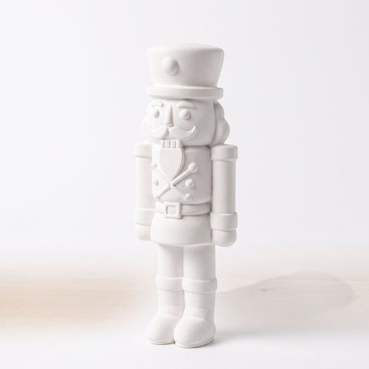 Deko-Nussknacker aus weißer Gießmasse (13x5 cm) in der Gesamtansicht vor hellem Hintergrund.