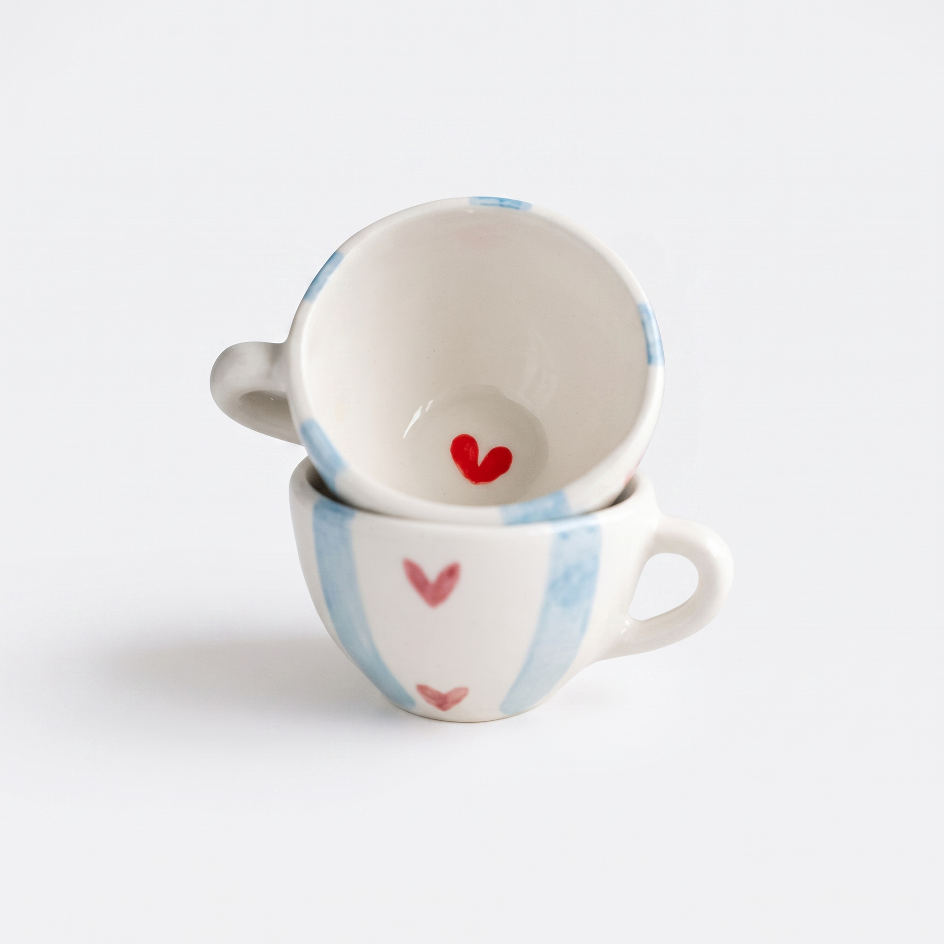 Tassenset Love Stripes (2er Set) mit blauen Streifen und roten Herzen in der Gesamtansicht vor hellem Hintergrund.