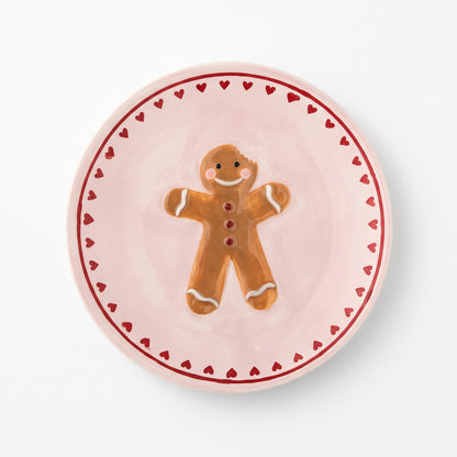 Kleines Steingut-Teller Binna in Rosé mit handbemaltem Lebkuchen-Motiv auf weißem Hintergrund.