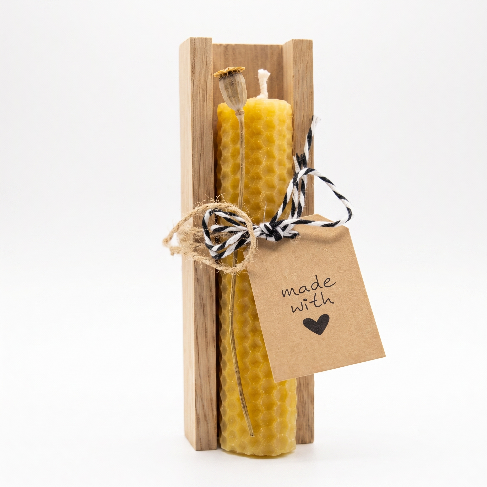 Fertiges Geschenkset aus einer handgedrehten Bienenwachskerze in einer Schale aus echtem Eichenholz mit schwarz-weiß-gestreifter Schnur verziert.