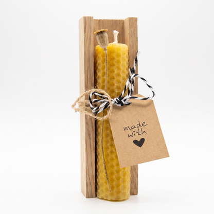 Fertiges Geschenkset aus einer handgedrehten Bienenwachskerze in einer Schale aus echtem Eichenholz mit schwarz-weiß-gestreifter Schnur verziert.