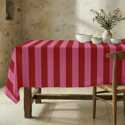 Die sommerlich gestreifte Tischdecke einladend gedeckt in einem rustikalen Esszimmer.