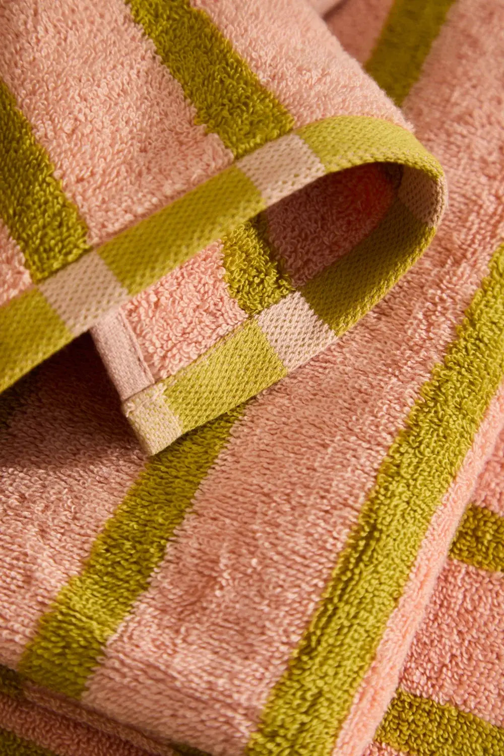 Nahaufnahme der schweren 530 g/m² Jacquard-Frottierbaumwolle des gestreiften Handtuchs.